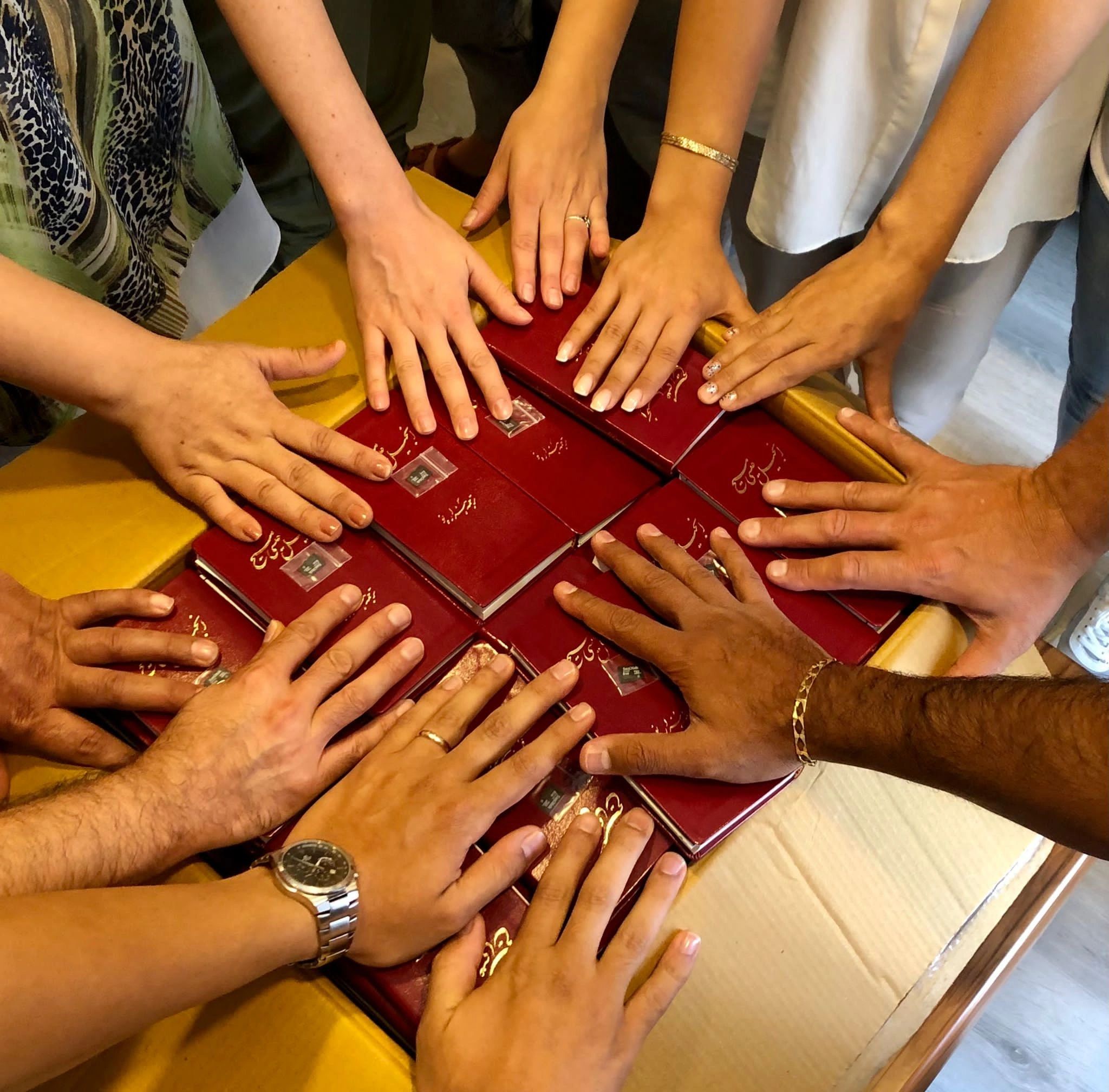 Hands together over Bibles — Every Nation Project